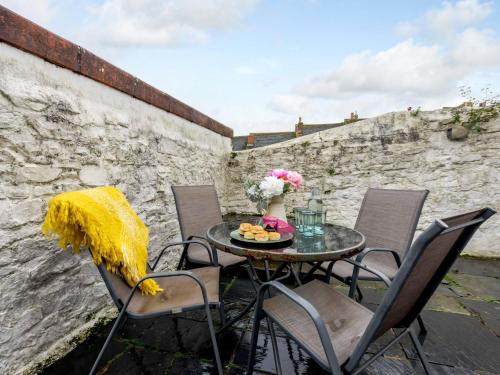 a table with a vase of flowers on a patio at 2 Bed in Appledore 63084 in Appledore