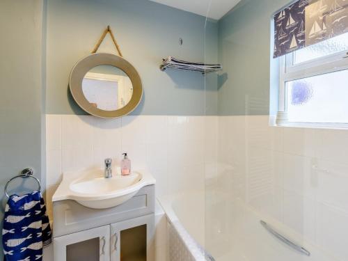 a white bathroom with a sink and a mirror at 2 Bed in Appledore 63084 in Appledore