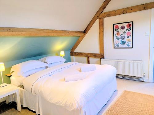 a bedroom with two white beds in a room at South Cotswolds cottage in Great Somerford