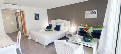 a bedroom with a white bed and a table with a table at Studio Luxe vue mer in Le Gosier