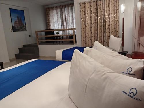 a hotel room with a bed with pillows at Aqua Hotel Cusco in Cusco