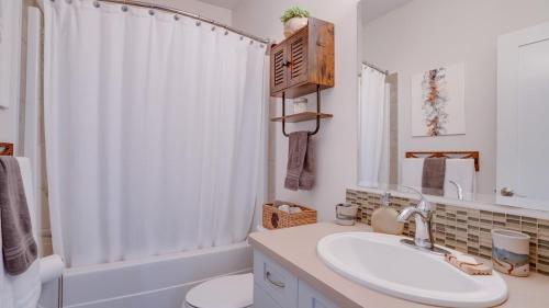 a bathroom with a sink and a toilet and a shower at Hot Tub, Pool, City Views, close to Silver Star in Vernon