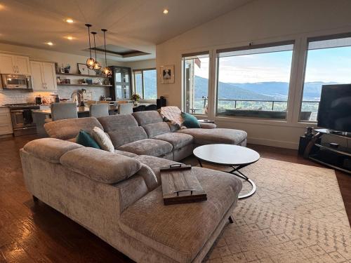 a living room with a couch and a table at Hot Tub, Pool, City Views, close to Silver Star in Vernon