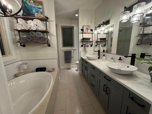 a large bathroom with two sinks and a tub and a tub at Hot Tub, Pool, City Views, close to Silver Star in Vernon