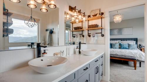 a bathroom with two sinks and a large mirror at Hot Tub, Pool, City Views, close to Silver Star in Vernon