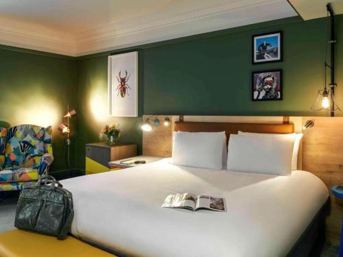 a bedroom with a large white bed with a backpack on it at The Grand Bristol City Center By Dancenter in Bristol