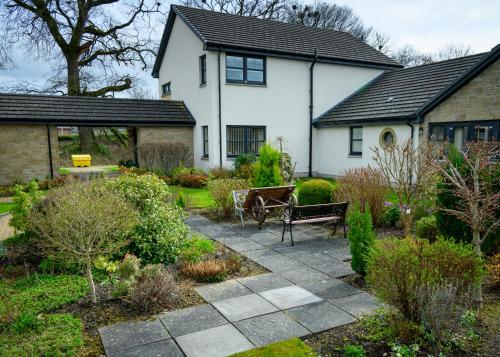 a garden with a bench and a house at 2 Bed Property, Beauly in Beauly