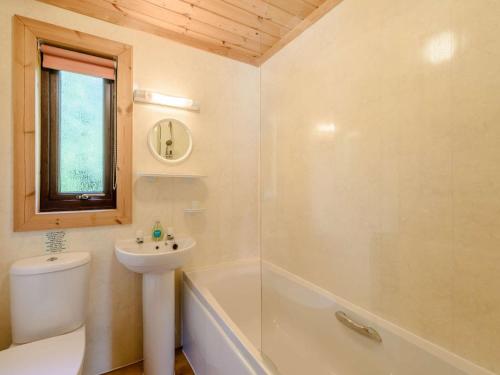 a bathroom with a sink and a toilet and a tub at 3 Bed in Clovelly 85290 in Woolfardisworthy