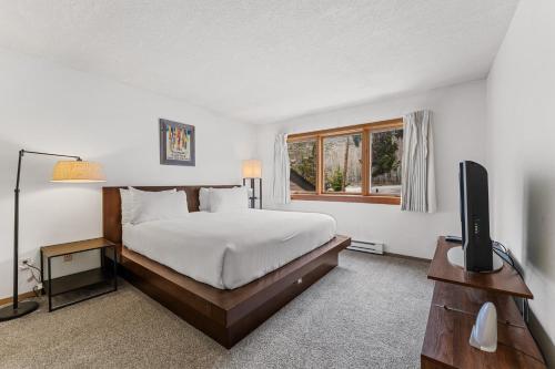 a bedroom with a bed and a tv and a window at Quicksilver 1645 by Summit County Mountain Retreats in Keystone
