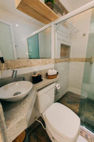 a bathroom with a toilet and a sink at Canto da Canoa in Arraial do Cabo