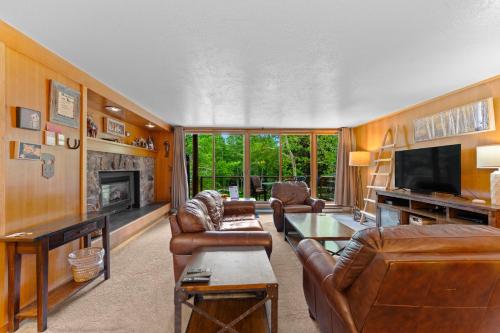 a living room with leather furniture and a fireplace at Lodgepole 2003 by Summit County Mountain Retreats in Keystone