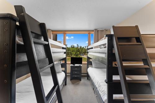 a dorm room with two bunk beds and a desk at Lodgepole 2003 by Summit County Mountain Retreats in Keystone