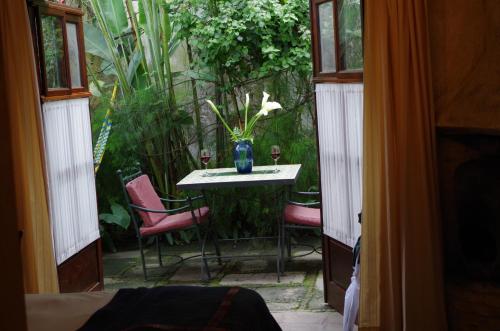 a room with a table and chairs and a vase with flowers at Meson Panza Verde in Antigua Guatemala