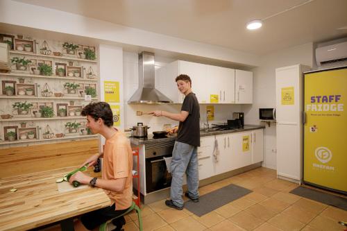 two men are standing in a kitchen preparing food at Onefam Batlló in Barcelona