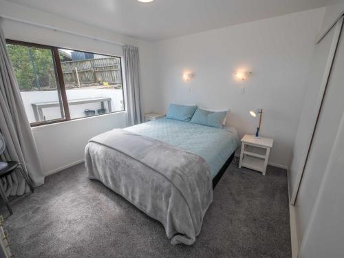 a bedroom with a large bed and a window at The Garden Flat in Mangonui