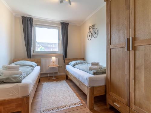 Dos camas en una habitación pequeña con ventana. en Ferienhaus in Tönning, en Tönning