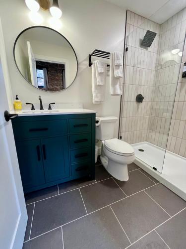 a bathroom with a toilet and a sink and a mirror at The Produce Suites in Toledo