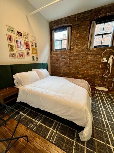 a bed in a room with a brick wall at The Produce Suites in Toledo