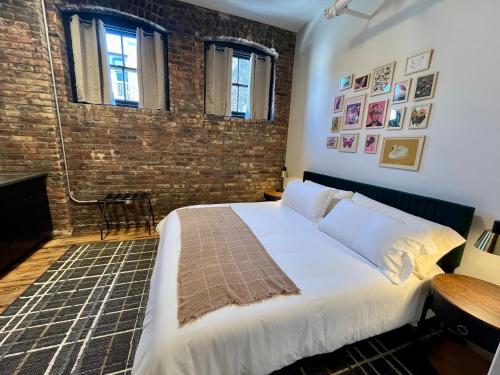 a bedroom with a bed and a brick wall at The Produce Suites in Toledo