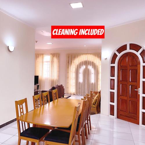 a dining room with a wooden table and chairs at Paramaribo Villa Near Vibrant District incl Kitchen Household Service in Paramaribo