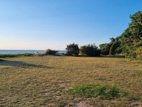 a field of grass with the ocean in the background at 5 person holiday home in Mörbylånga-By Traum in Mörbylånga