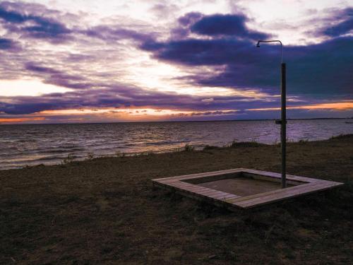 a bench on the beach with a street light and the ocean at 5 person holiday home in Mörbylånga-By Traum in Mörbylånga