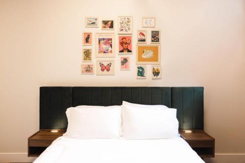 a bed with a black headboard with pictures on the wall at The Produce Suites in Toledo