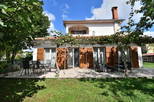 a house with chairs and a table in front of it at House Villa Lili in Žminj