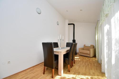 a dining room with a table and black chairs at House Villa Lili in Žminj
