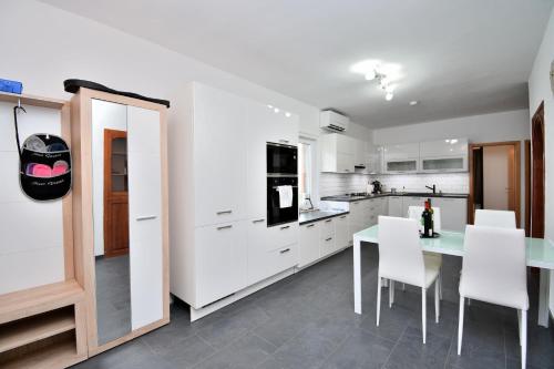 a kitchen with white cabinets and a table and chairs at House Villa Lili in Žminj