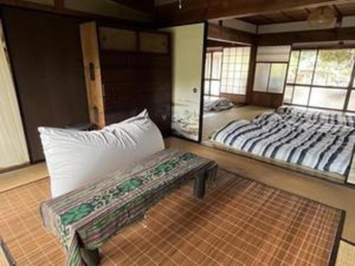 a room with two beds and a bench in it at KuraKura Village - Vacation STAY 39459v in Kami-ichi