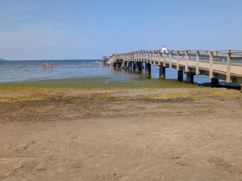 a pier in the ocean with people standing on it at Nice apartment near the beach-By Traum in Mellbystrand