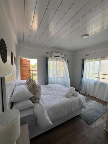 ルサカにあるThe Mallside Apartmentsの白いシーツと枕が付いた大きなベッドのある寝室