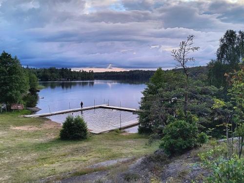 a person standing on a dock on a lake at 4 person holiday home in Holmsjö-By Traum in Holmsjö