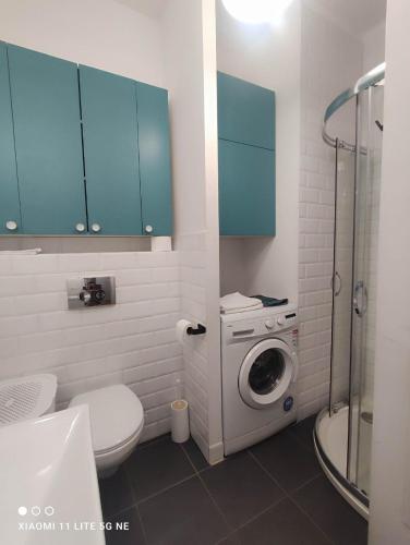 a bathroom with a washing machine and blue cabinets at Warsaw Shire in Warsaw