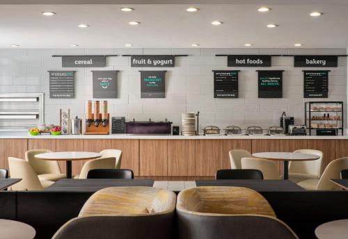 ein Restaurant mit Tischen und Stühlen und einer Theke in der Unterkunft Holiday Inn Meridian East I 59 / I 20 in Meridian