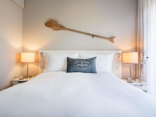 a bedroom with a large white bed and two lamps at Sofitel Quiberon Thalassa sea & spa in Quiberon
