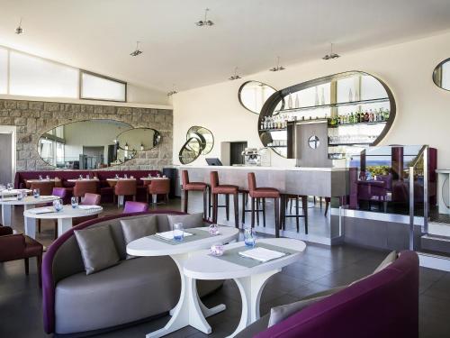 a restaurant with tables and chairs and a bar at Sofitel Quiberon Thalassa sea & spa in Quiberon