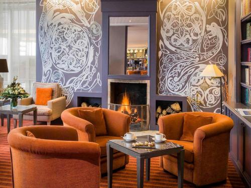 a living room with two chairs and a fireplace at Sofitel Quiberon Thalassa sea & spa in Quiberon
