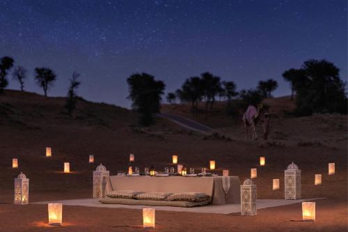 a table with candles in the desert at night at The Ritz-Carlton Ras Al Khaimah, Al Wadi Desert in Ras al Khaimah