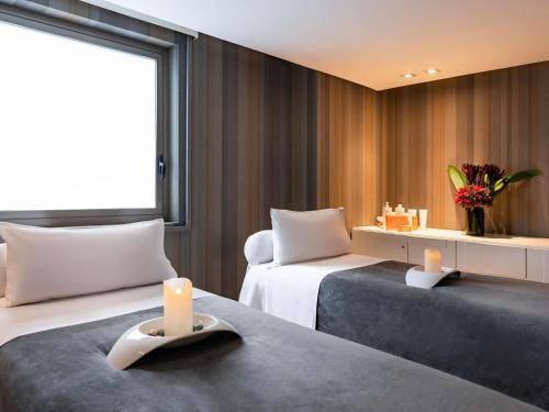a hotel room with two beds and two candles at Sofitel Bogota Victoria Regia in Bogotá