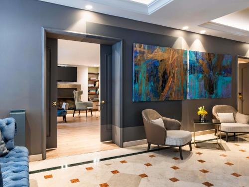 a lobby with chairs and a painting on the wall at Sofitel Bogota Victoria Regia in Bogotá