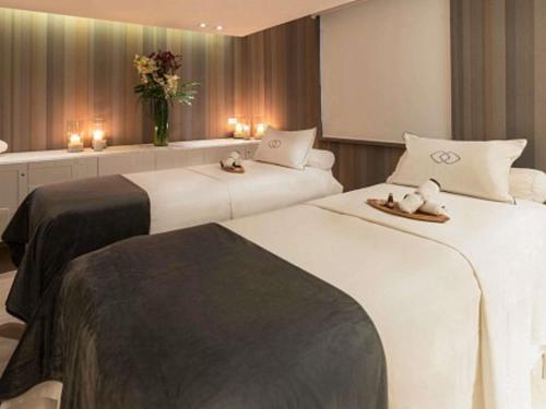 two beds in a hotel room with candles and flowers at Sofitel Bogota Victoria Regia in Bogotá