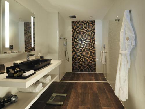a bathroom with a black sink and a shower at Pullman Dakar Teranga in Dakar
