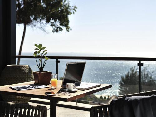 a table with a laptop computer on a balcony at Pullman Dakar Teranga in Dakar