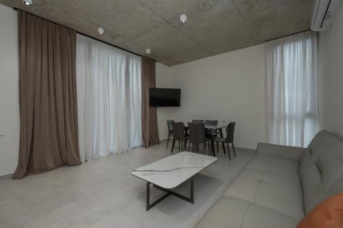a living room with a couch and a table at 5 Star Duluxe Apartment in Villa Magnetica in Ozurgetʼi