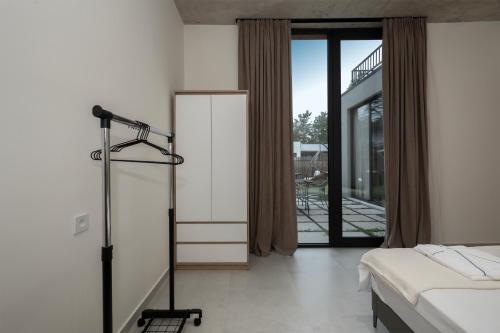 a bedroom with a bed and a glass door at 5 Star Duluxe Apartment in Villa Magnetica in Ozurgetʼi