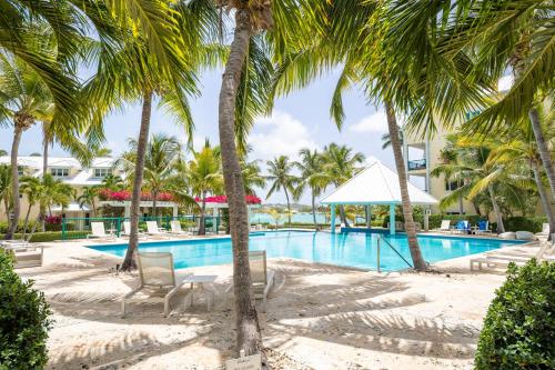 a pool at the resort with palm trees at 2 Bdrm Stunning Marina View at The Yacht Club C5 in Providenciales