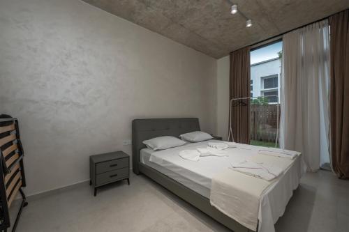 a bedroom with a bed and a window at 5 Star Duluxe Apartment in Villa Magnetica in Ozurgetʼi