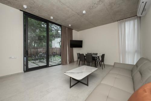 a living room with a couch and a table at 5 Star Duluxe Apartment in Villa Magnetica in Ozurgetʼi